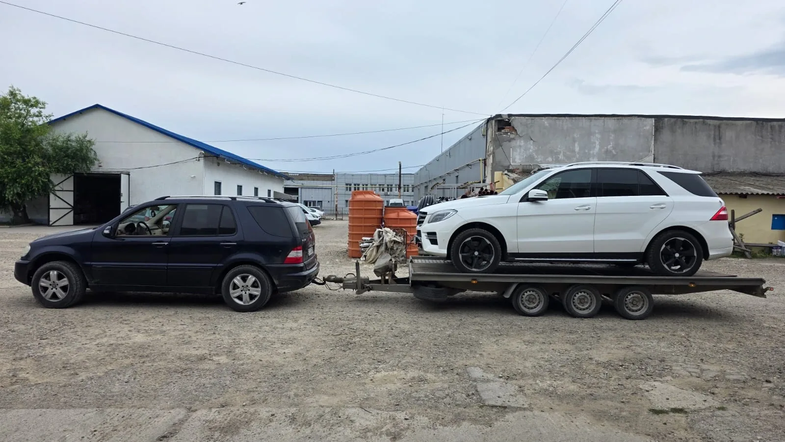 Un Mercedes GLE alb urcat pe remorca-platformă cu trei axe.